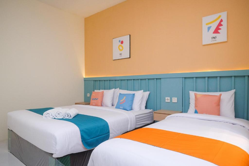Sans Hotel City Inn Solo by RedDoorz tesisinde bir odada yatak veya yataklar