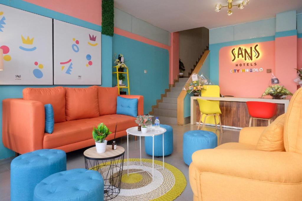 a waiting room with orange and blue furniture at Sans Hotel City Inn Solo by RedDoorz in Solo