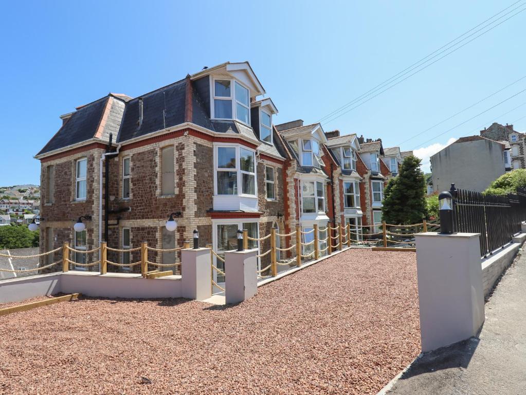 una gran casa de ladrillo con una valla alrededor en Bradley House, en Ilfracombe