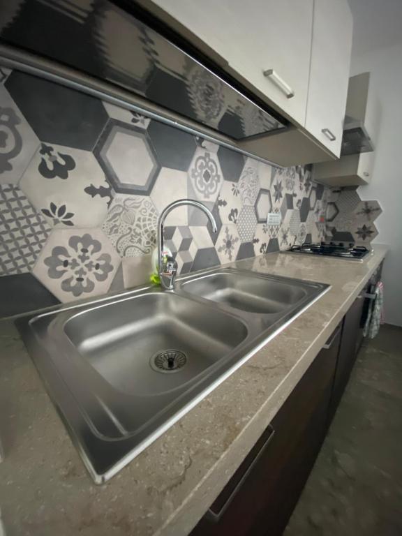 un fregadero de acero inoxidable en una cocina con azulejos en Casa Royal, en Ausonia