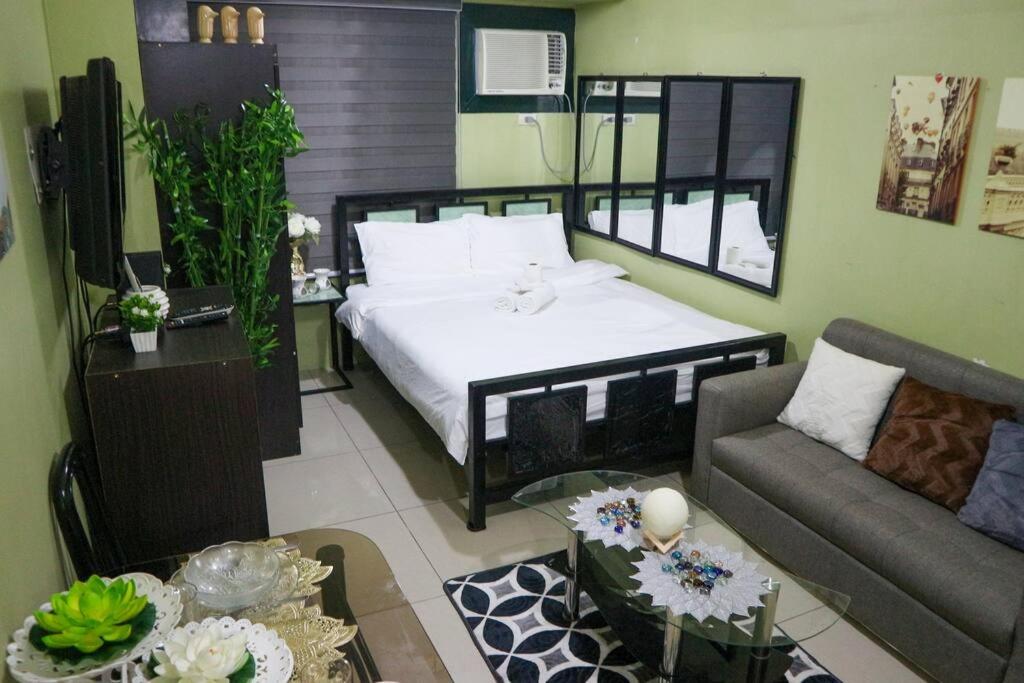 uma sala de estar com uma cama e um sofá em Stylish Luxe Apartment very near Makati Square em Manila