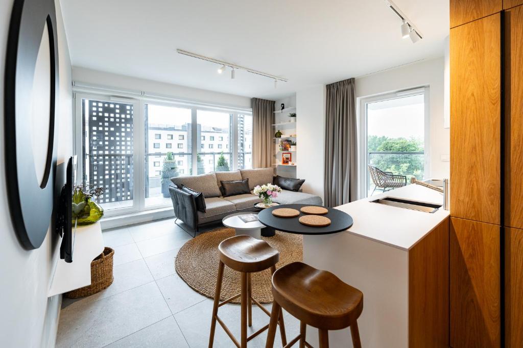 cocina y sala de estar con sofá y mesa en Apartamenty Tespis - Sokolska 30 Towers en Katowice