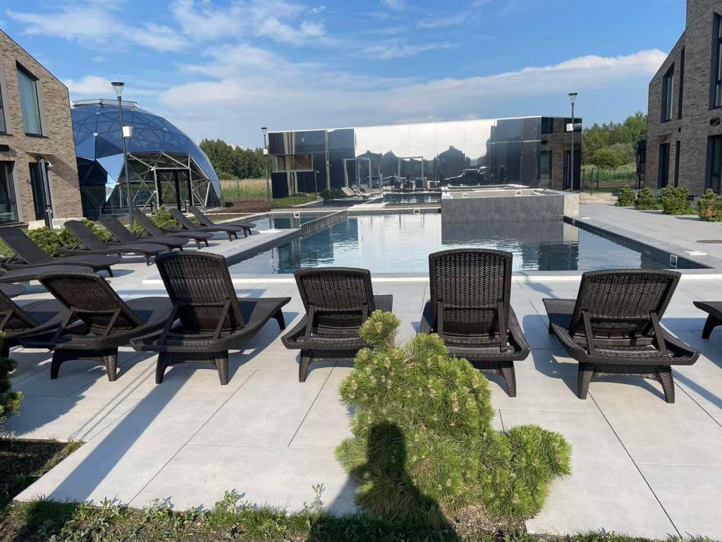 a group of chairs sitting next to a swimming pool at Emgus cottages (Nature & Comfort) in Palanga