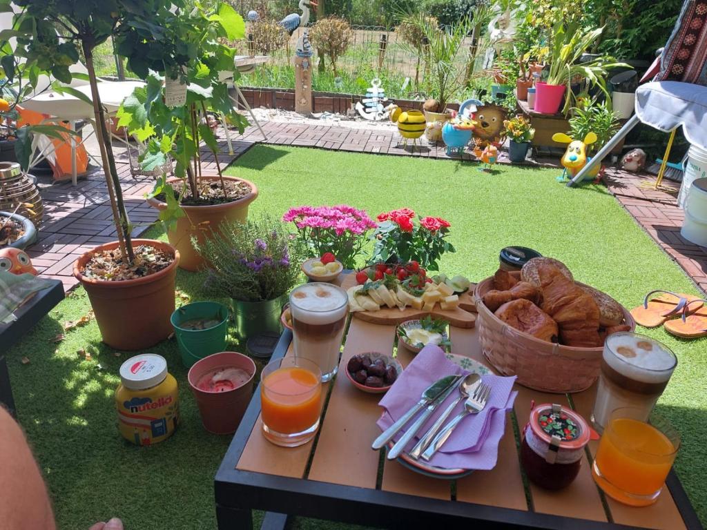 a picnic table with food and drinks on the grass at Gemütliches Zimmer in ruhiger Umgebung in Lyss