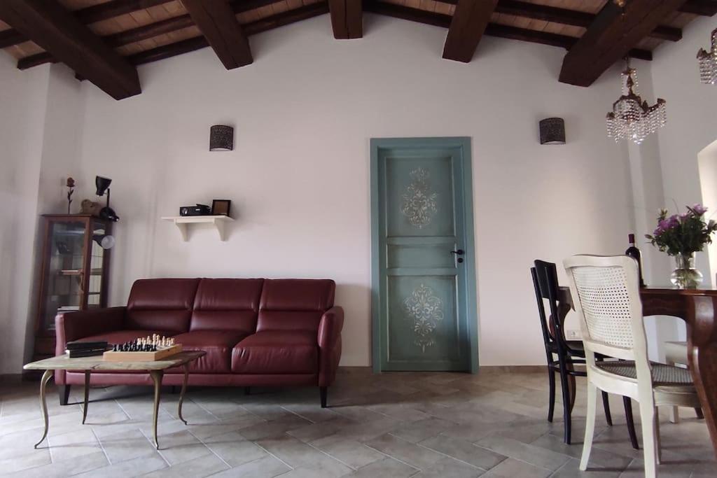 een woonkamer met een rode bank en een tafel bij Il Racconto Aria in Nocera Umbra