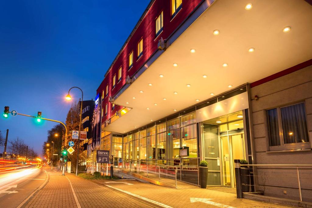 科隆的住宿－Essential by Dorint Köln-Junkersdorf，城市街道上的建筑,有绿色的交通灯