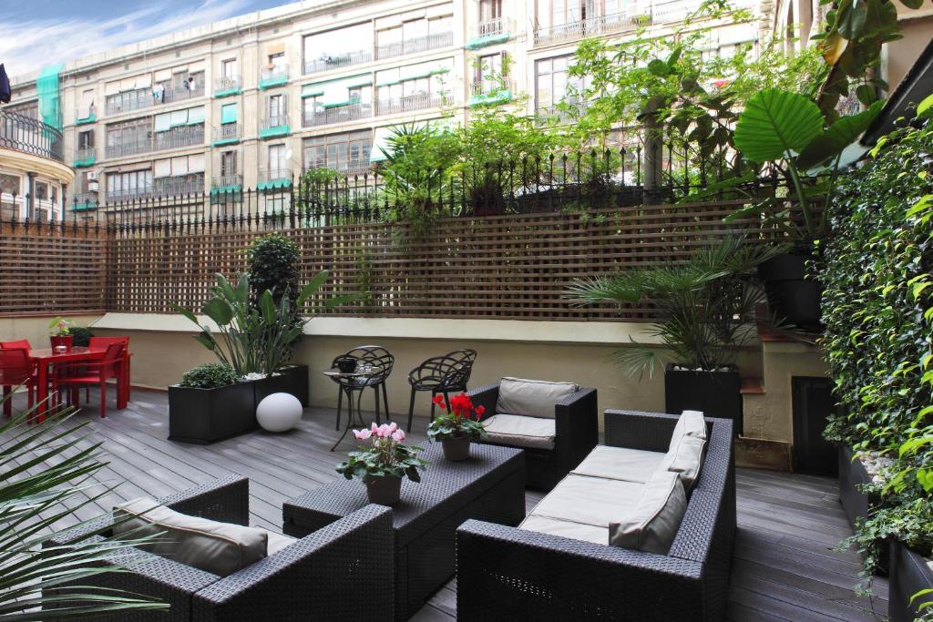 a patio with couches and tables and a building at Anba Boutique in Barcelona