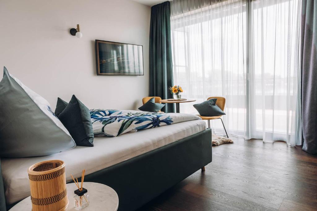 a bedroom with a bed and a large window at ANKERPUNKT Seeblick 