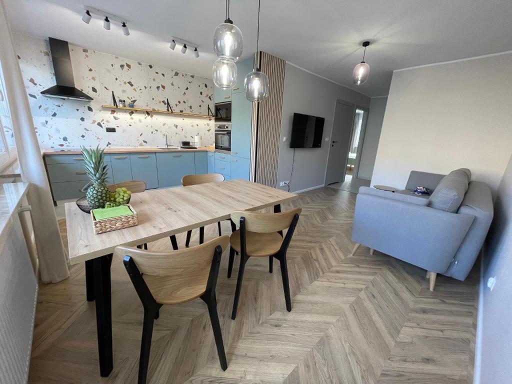 a kitchen and dining room with a table and a couch at Apartament w Śródmieściu in Gdynia