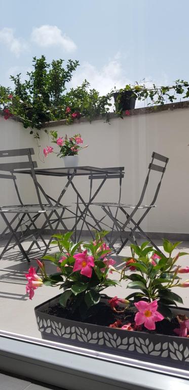 una mesa y sillas con flores en el balcón en Il Cortile Segreto, en Lecce