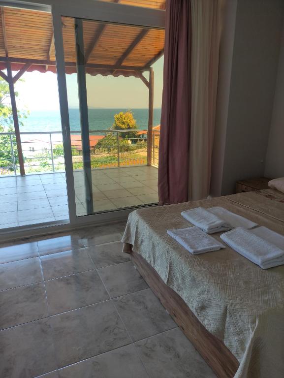 a bedroom with a bed and a view of the ocean at Limonlu Bahçe Butik Otel in Karaburun