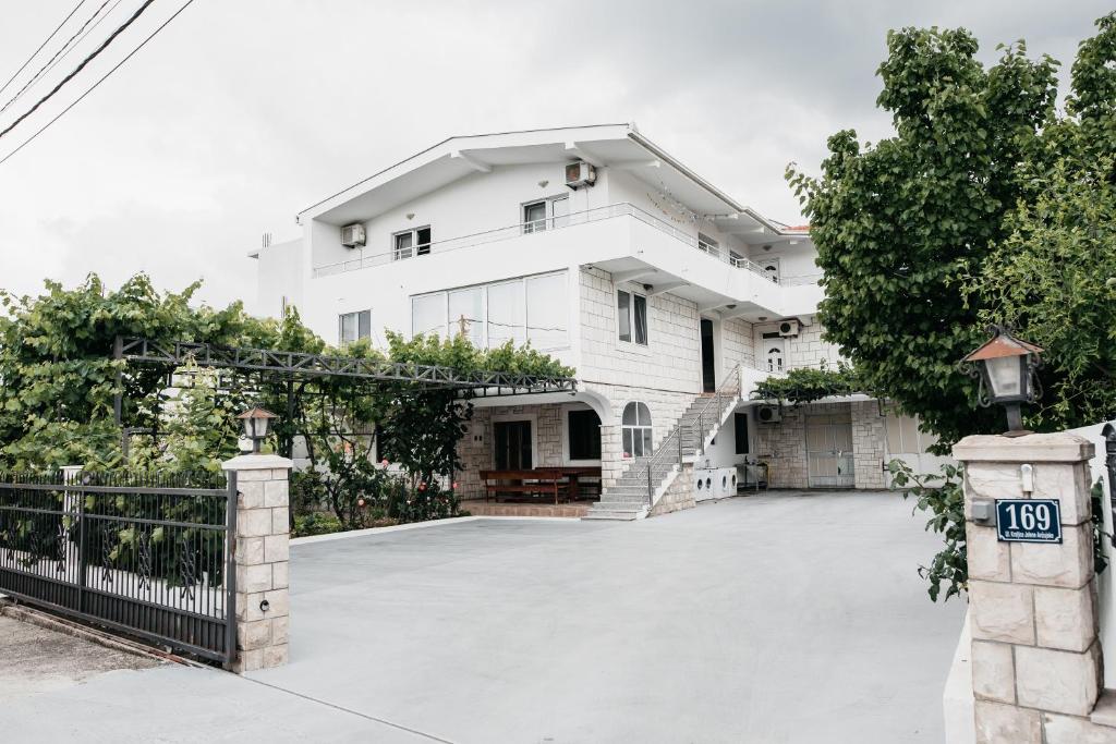 a white house with a gate and a driveway at Guest House Lalic in Bar