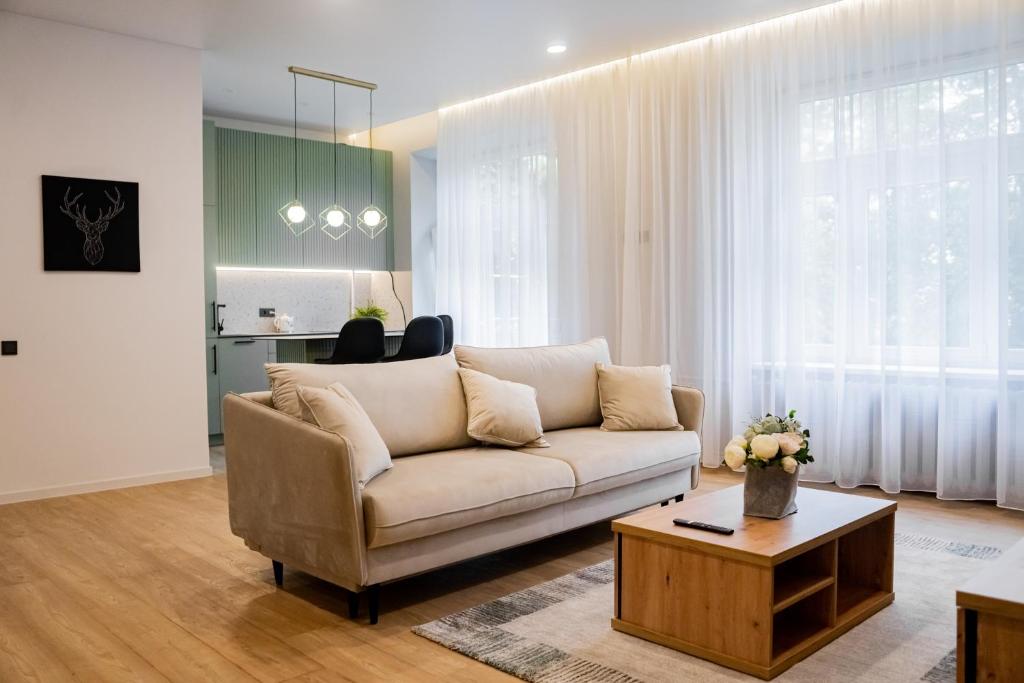 ein Wohnzimmer mit Sofa und Tisch in der Unterkunft Meridiano apartamentai in Klaipėda