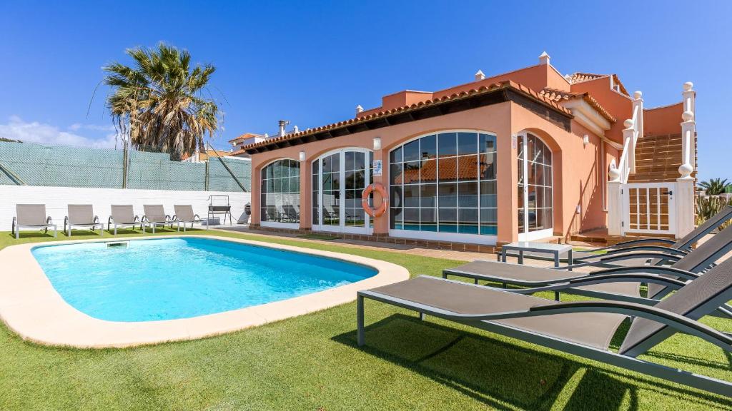 a villa with a swimming pool and a house at Chalet Mar in Caleta De Fuste