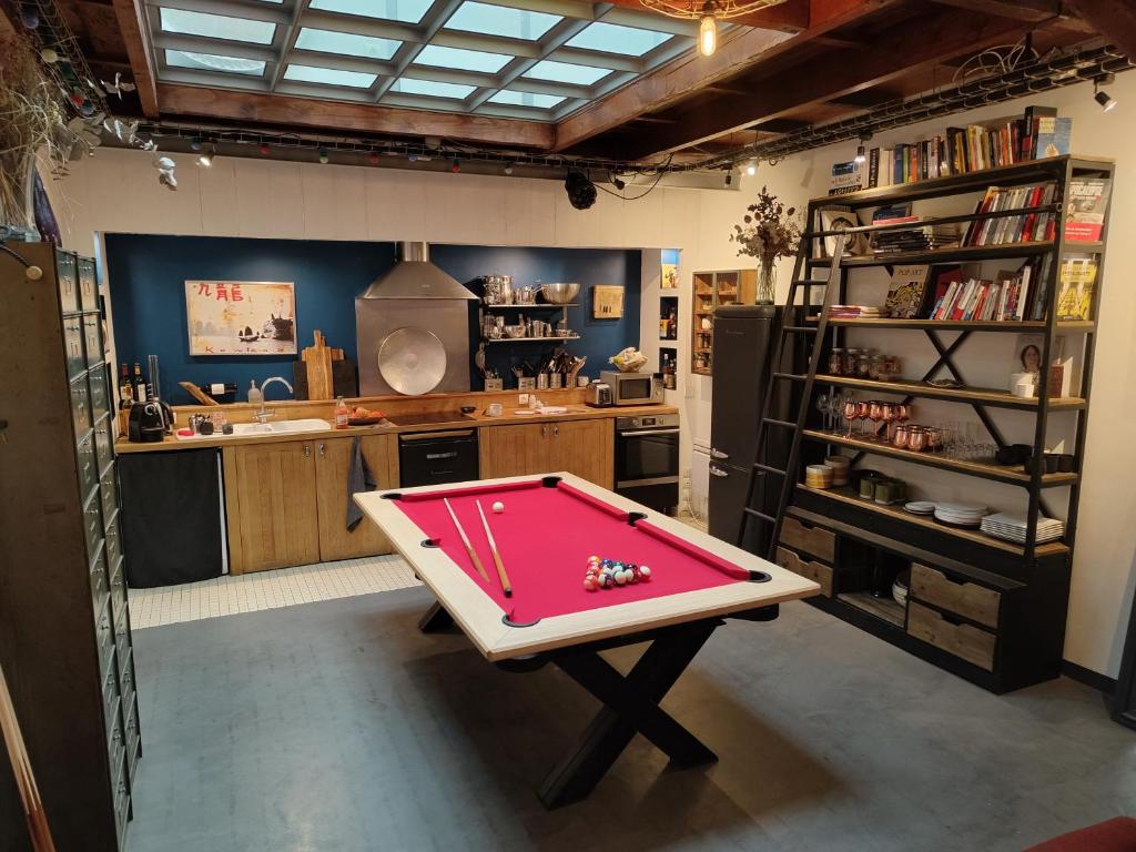 a room with a pool table in the middle of a kitchen at Atelier d'artiste - Loft with garden center of Paris in Paris