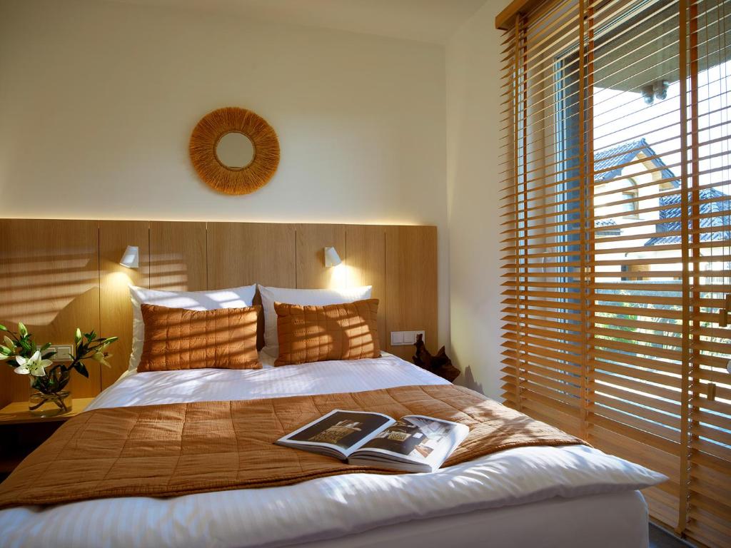 a bedroom with a bed with a book on it at Lake-Apart Apartamenty Mielno in Mielno