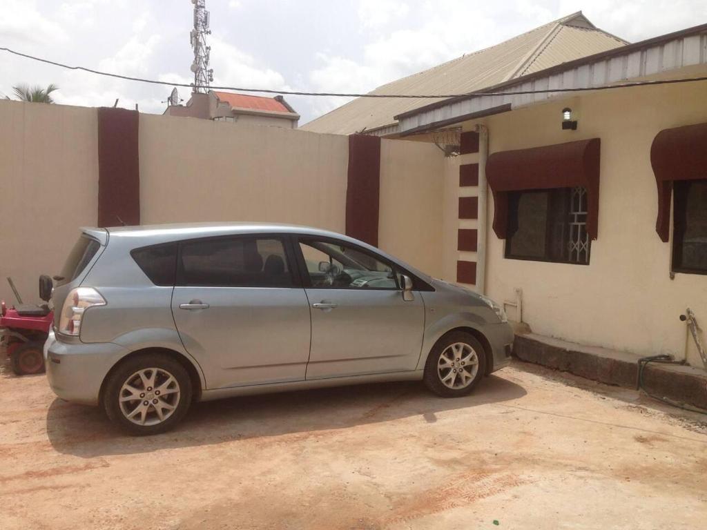 ベニンシティにあるCharming 2-Bed Cottage in Benin Cityの家の前に停められた銀車