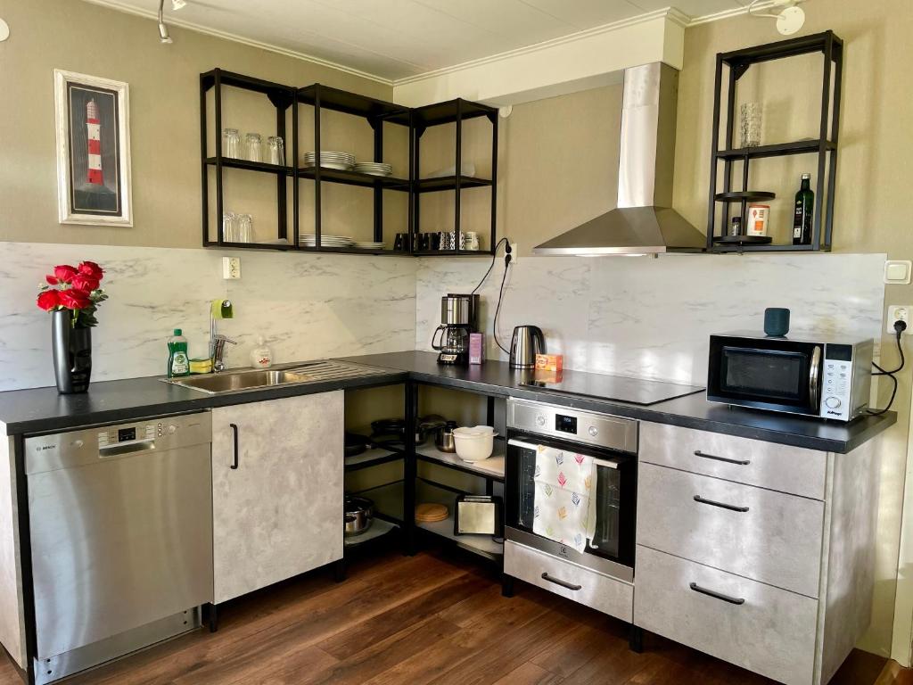 a kitchen with a sink and a microwave at Centralt belägen villa i Öjebyn, Piteå in Piteå