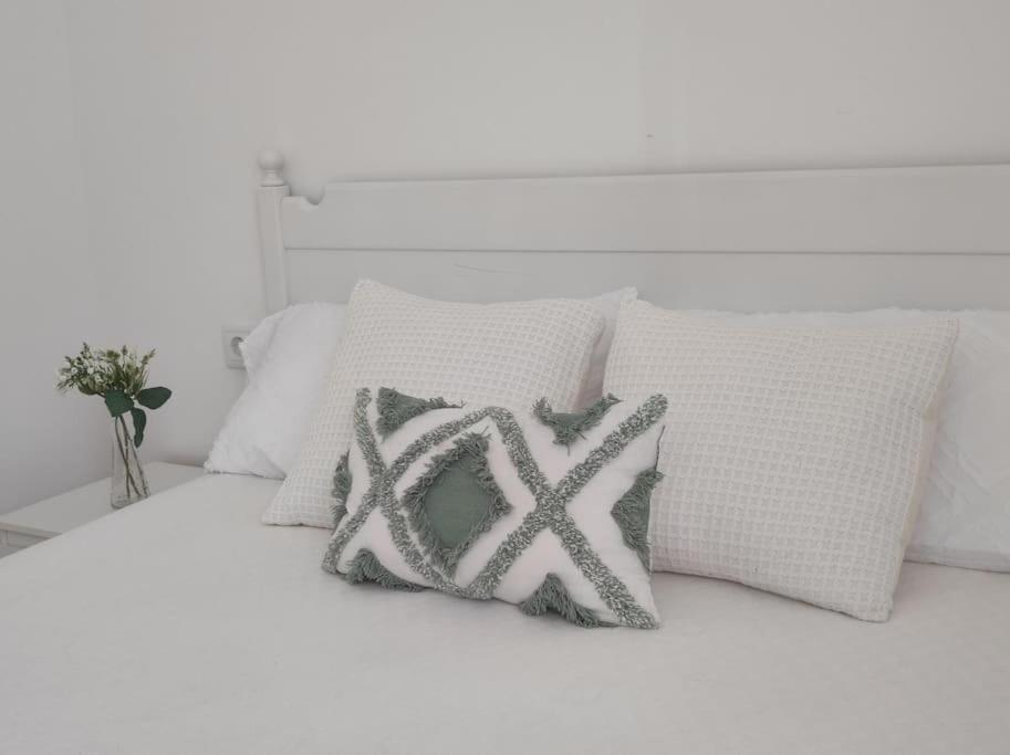 a white bed with two pillows on it at Casa Dina II. in Carballino