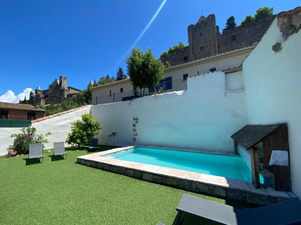 una piscina en el patio trasero de un edificio en La Maison de La Tour Pinte, en Carcassonne