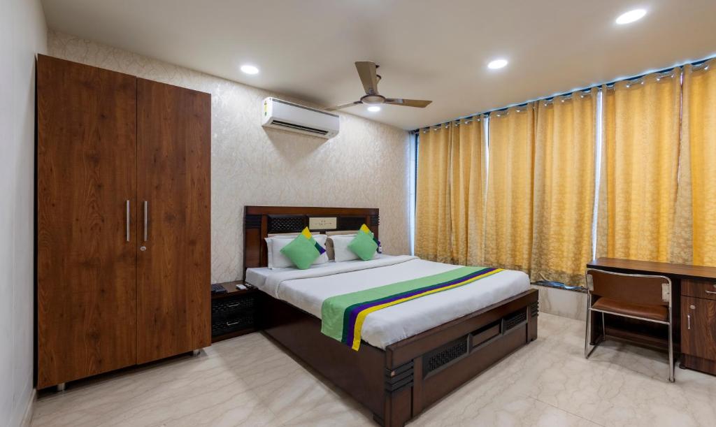 a bedroom with a bed and a dresser and a desk at Treebo Trend MVM Residency in New Delhi