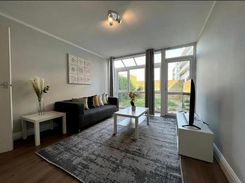 ein Wohnzimmer mit einem Sofa und einem Tisch in der Unterkunft Lovely 4bed property, London 8min to Oxford Street in London
