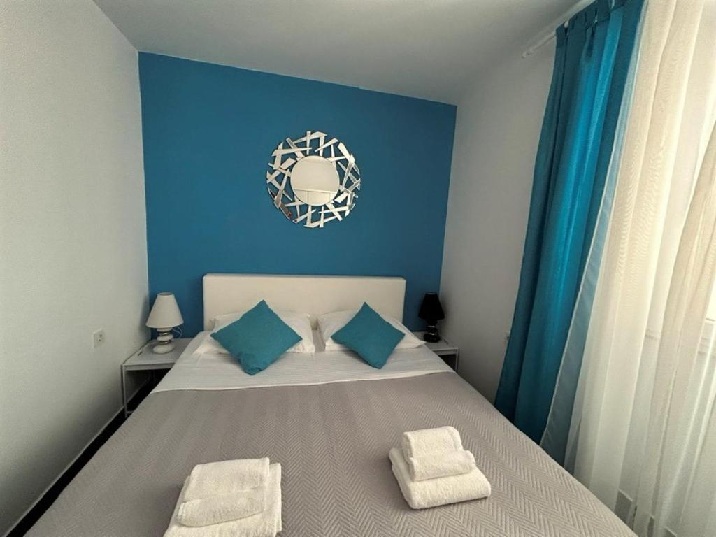 ein blaues Schlafzimmer mit einem Bett mit blauen Wänden in der Unterkunft Apartment Decumana in Krk