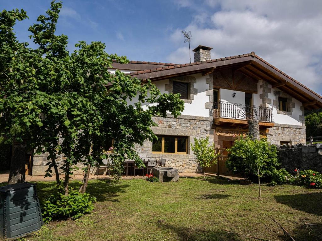 a large stone house with a tree in front of it at Tanbolin "with outlet for ELECTRIC vehicle" By Kabia Gestión in Gautegiz Arteaga