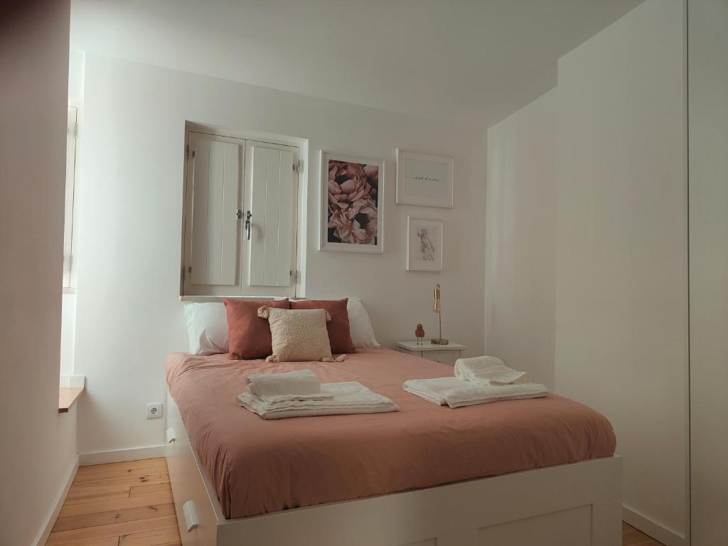 um quarto com uma cama com duas toalhas em Rose Essence Aparment - Exceptional balcony em Coimbra