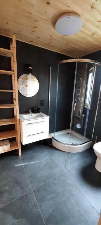 a bathroom with a shower and a sink and a mirror at Na Spokojnej Rodzinne Wakacje in Pogorzelica