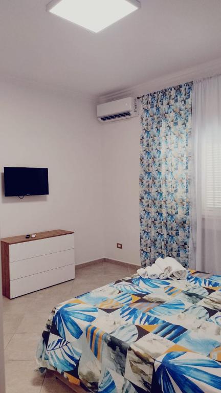 a bedroom with a bed and a tv on a wall at Lovin Puglia Vacation in Bari