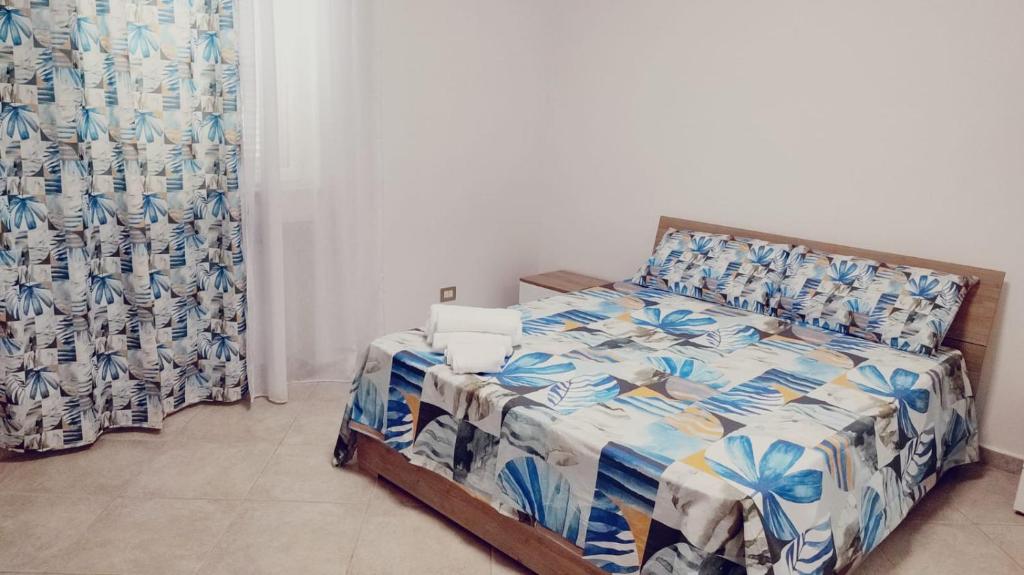 a bedroom with a bed with a blue and white comforter at Lovin Puglia Vacation in Bari
