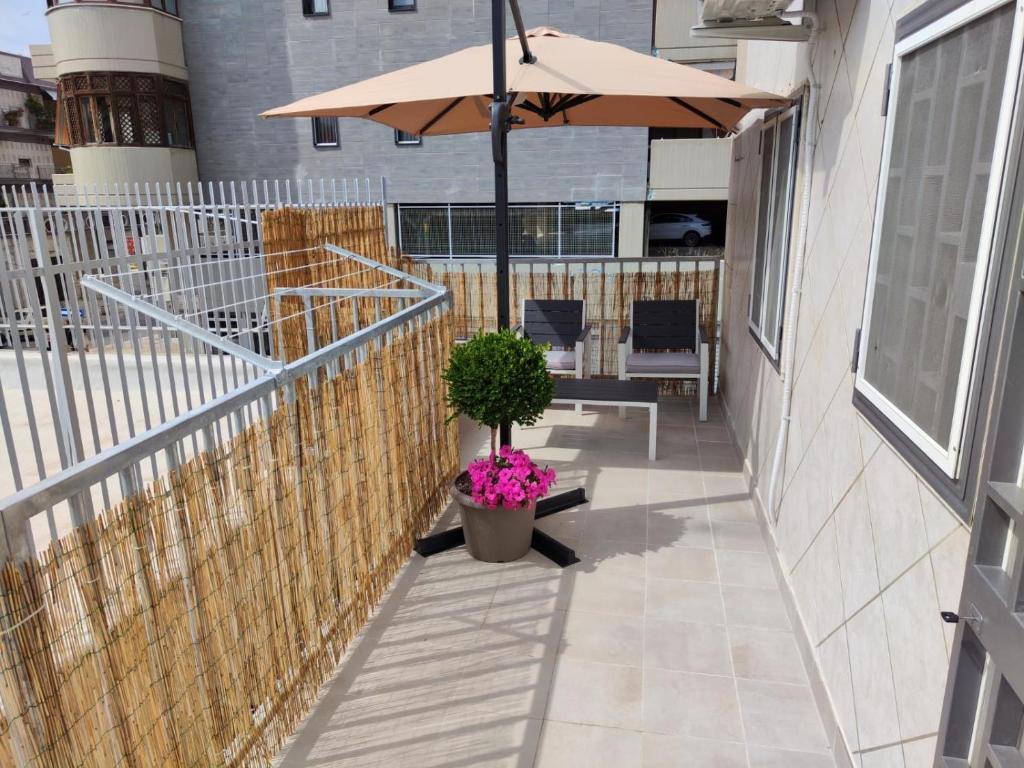 a patio with an umbrella and a potted plant at Lovin Puglia Vacation in Bari