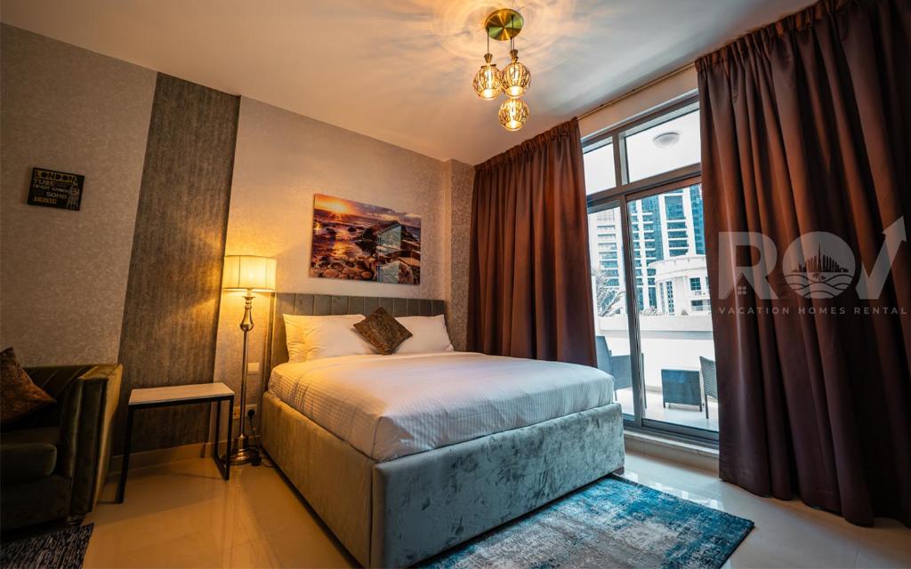 een slaapkamer met een bed en een groot raam bij Studio with Boulevard View in Dubai