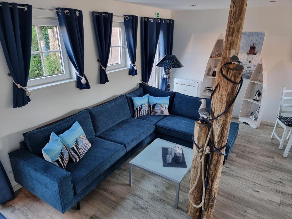 - un canapé bleu dans le salon avec des rideaux bleus dans l'établissement Vakantiehuis de Ankerplaats, à Kamperland