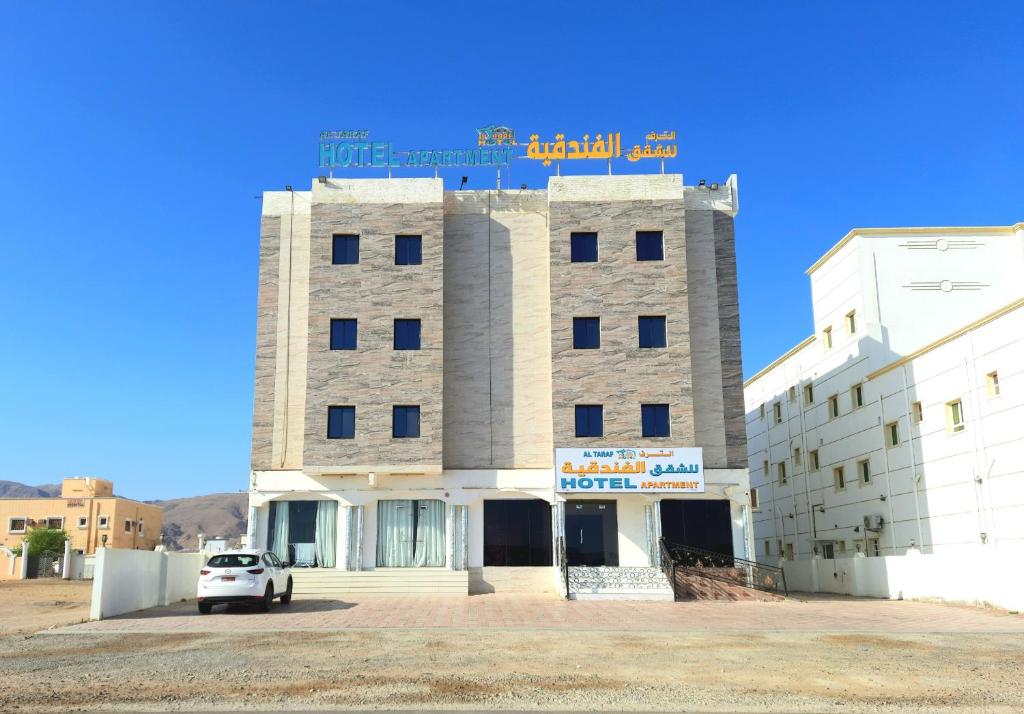 a building with a car parked in front of it at Al Taraf Hotel Apartment in Sur
