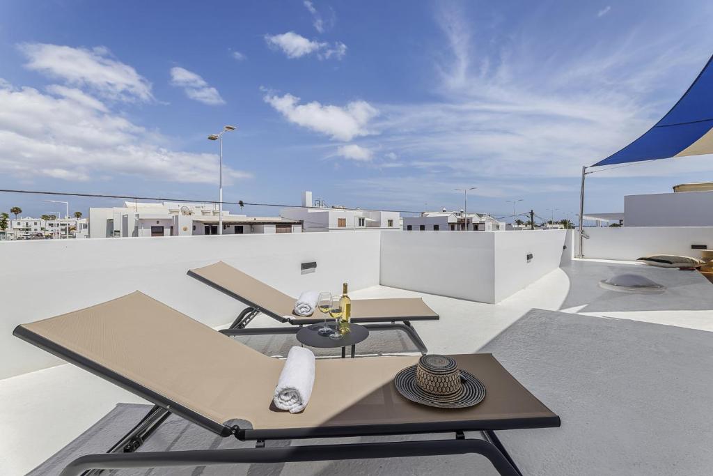 uma varanda com uma mesa e cadeiras num telhado em La casa de las velas em Playa Honda