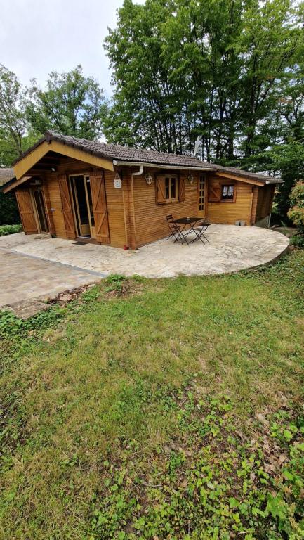 une cabane en rondins avec une table de pique-nique devant elle dans l'établissement Chalet, à Bazoches-sur-le-Betz