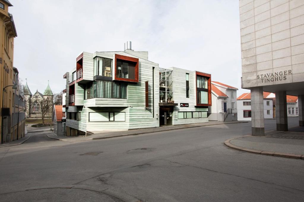 a wooden building on the side of a street at Klostergaarden leilighetshotell in Stavanger