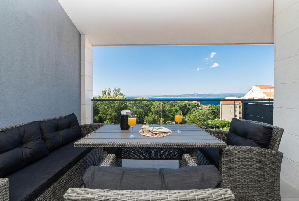 a patio with a table and chairs on a balcony at Apartmani Tona in Baška Voda