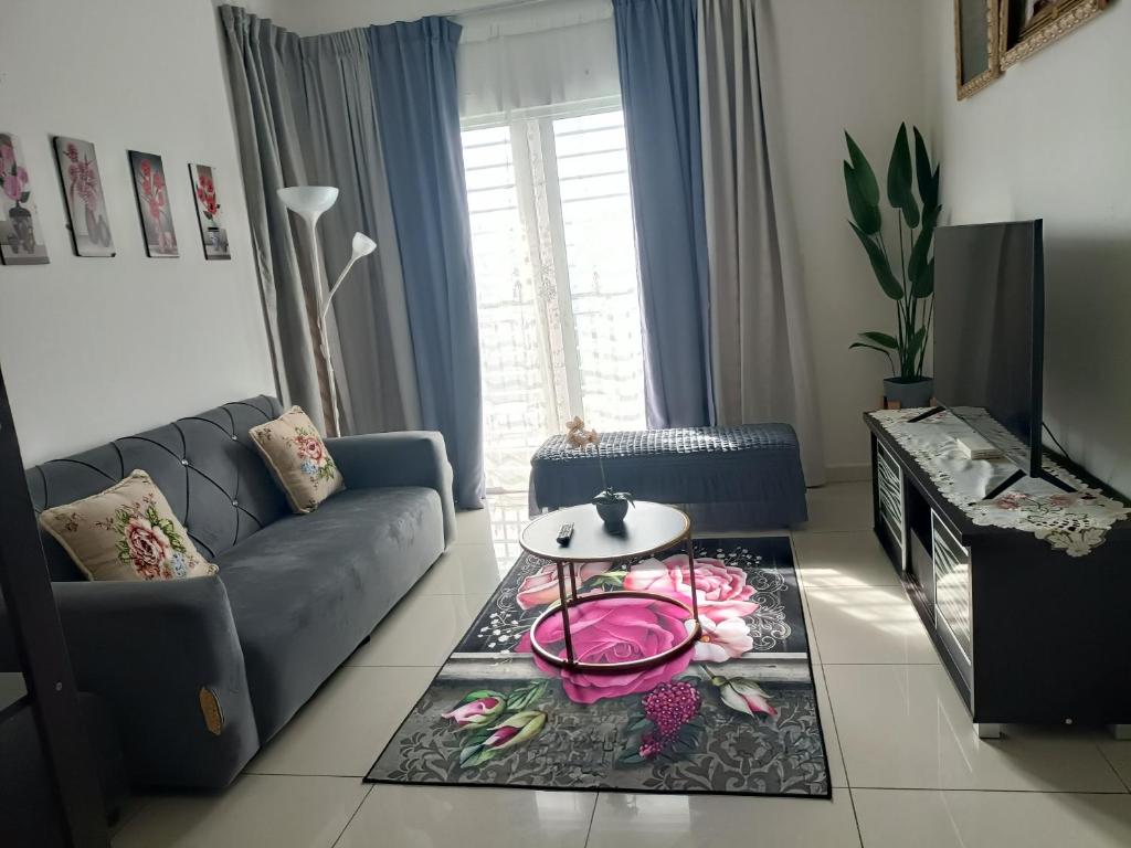 ein Wohnzimmer mit einem Sofa und einem Tisch in der Unterkunft Cikta Homestay at Southville City Savanna Suite in Kampong Tangkas