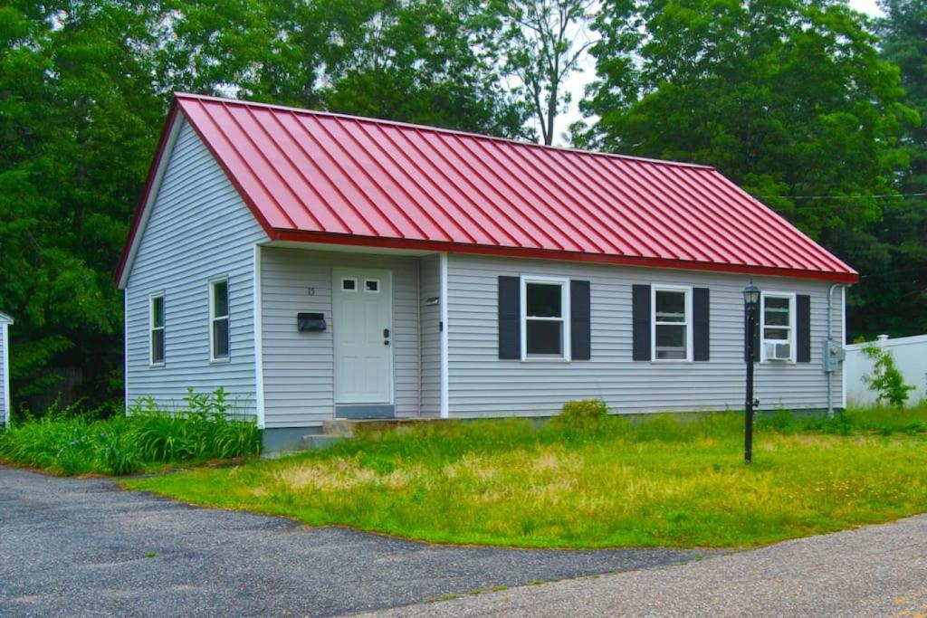 een klein wit huis met een rood dak bij 2 bedroom with queen sofa sleeper in Nashua