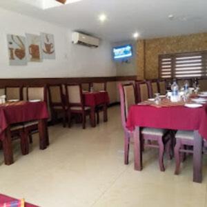 uma sala de jantar com mesas e cadeiras com toalha de mesa roxa em Kottaram Hotels Ottaplam em Palakkad