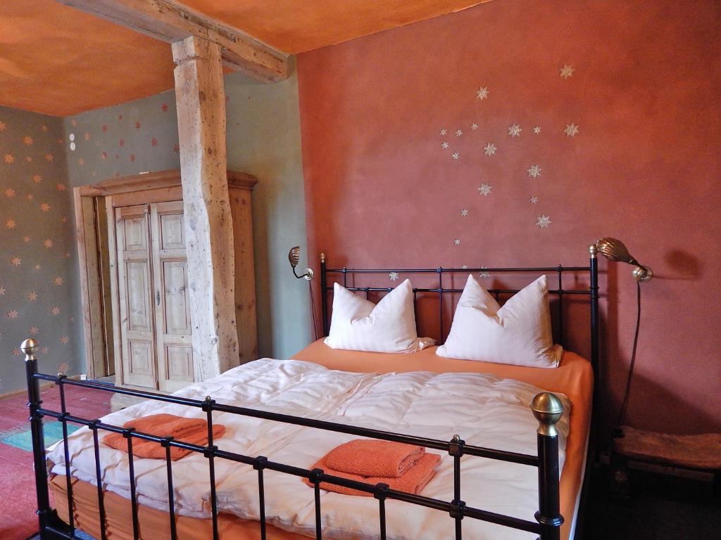 een slaapkamer met een bed met een oranje muur bij Kornspeicher Himmelpfort in Himmelpfort