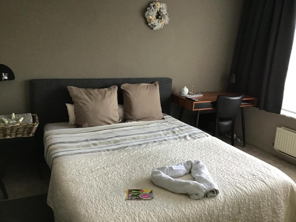 Postel nebo postele na pokoji v ubytování Guesthouse De Steenberg tweepersoonskamer met grote badkamer, kitchenette en tuinzicht op de eerste verdieping