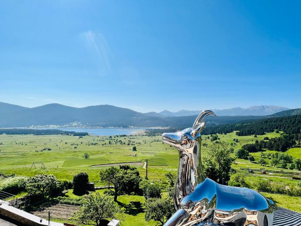 una estatua de una cabra en la cima de una colina en Le Refuge Cal Chalon , chalet de luxe au cœur du village en Les Angles