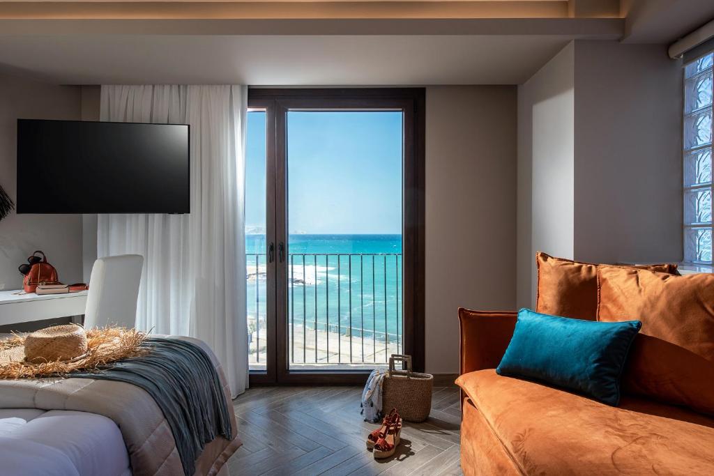 a bedroom with a bed and a view of the ocean at Vespera City Hotel in Heraklio