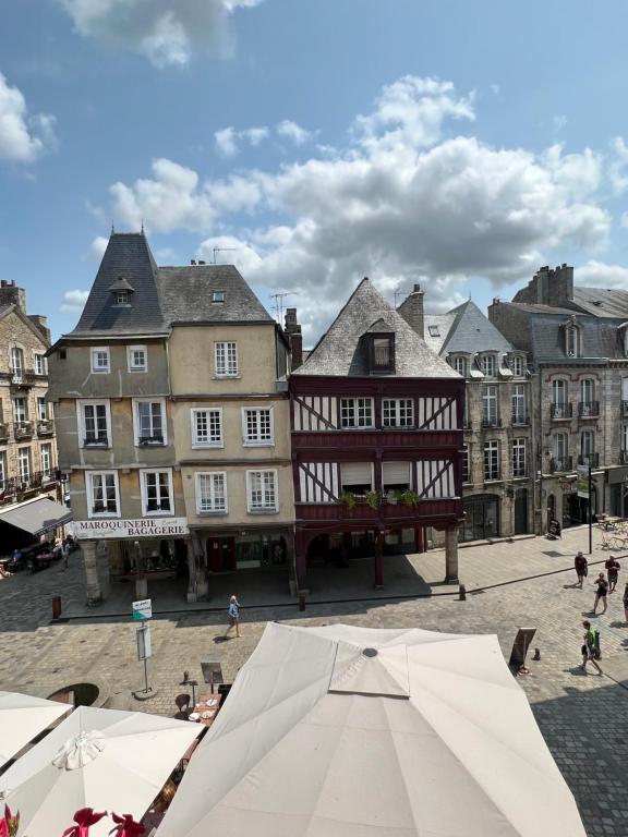 a town square with buildings and an umbrella at EGLANTINE 14 APPARTEMENT CENTRE HISTORIQUE DE DINAN in Dinan