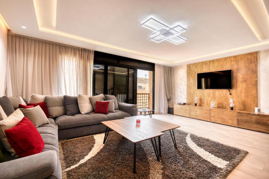 a living room with a couch and a tv at Aya - Taghazout - T3 Duplex Luxe - 4 or 5 Px in Taghazout