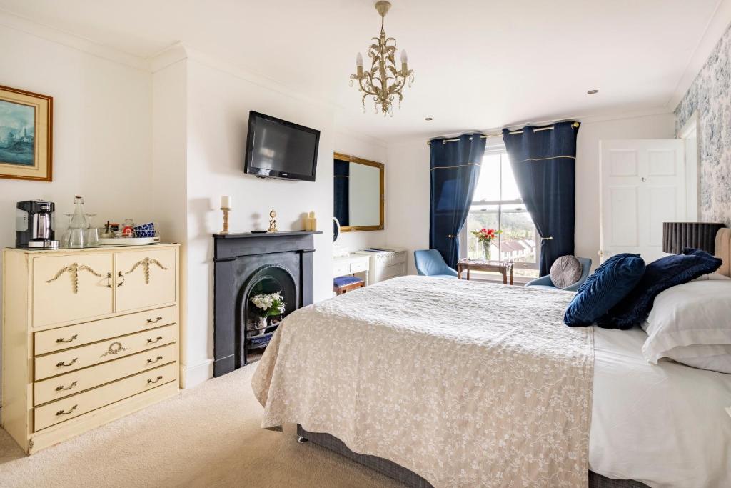 a bedroom with a bed and a fireplace at Penyvoel Hall in Llanymynech